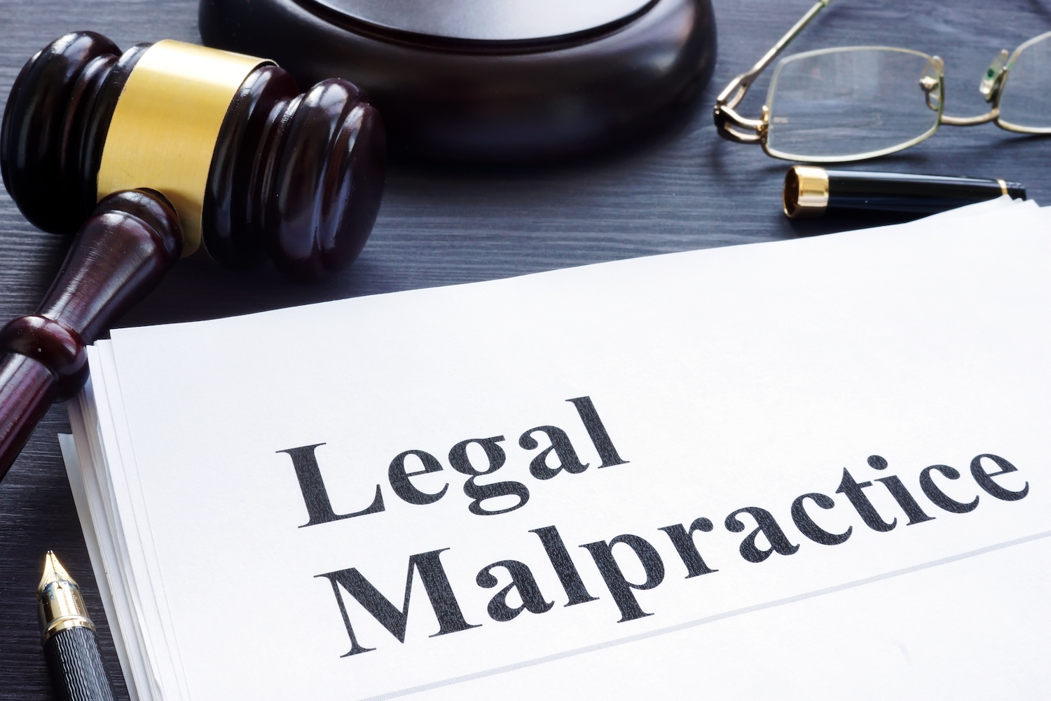 Legal malpractice graphic with gavel, glasses
