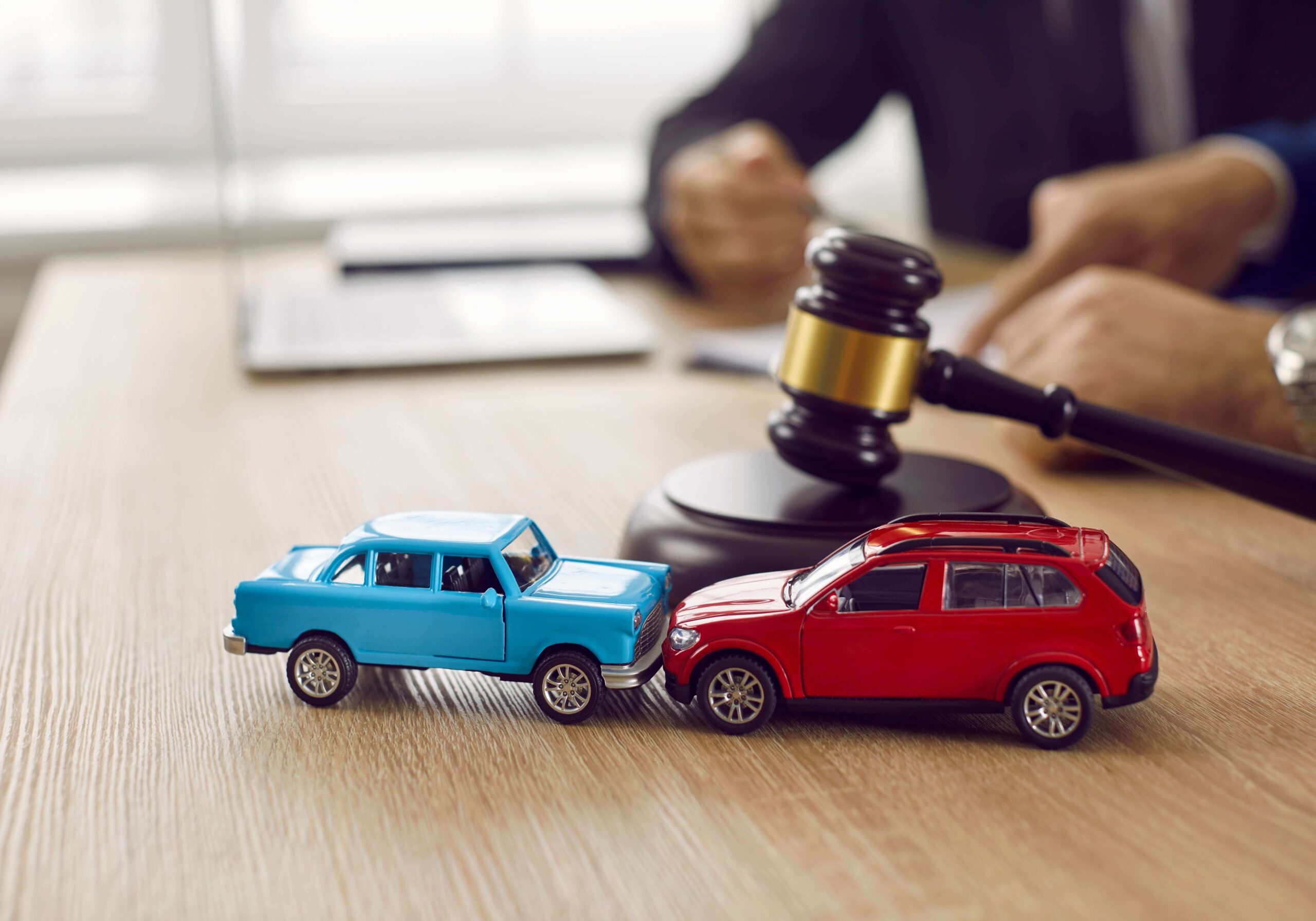 Small car accident model with gavel and computer
