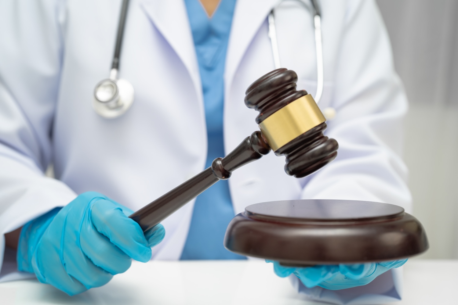 Medical professional wearing gloves hitting gavel