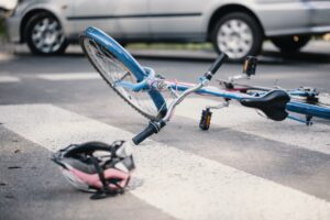 Pink helmet and blue kid's bike on a pedestrian crossing after a crash with a car